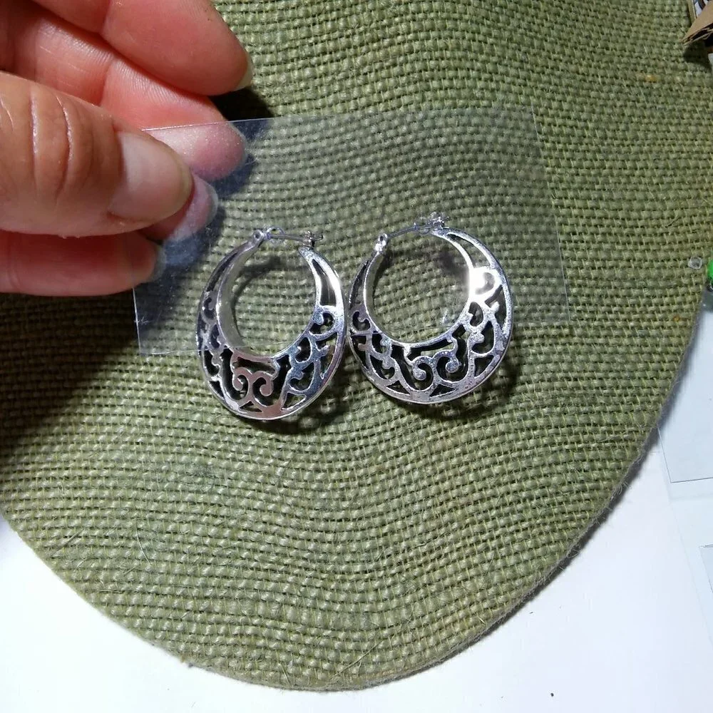 Women`s silver tone filigree hoop earrings. 1 1/8